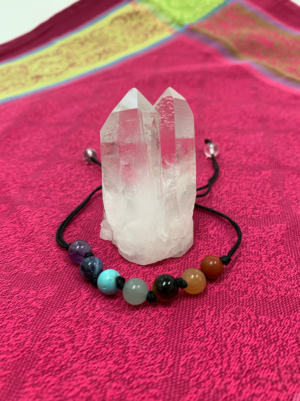 Adjustable Chakra power bracelet consists of 7 stones, one representing each of the 7 major chakras. It is artfully strung together with a strong, thin black cord and a tiny black knot between each chakra stone. Two additional clear quartz crystal stones embellish the adjustable part of the bracelet. 