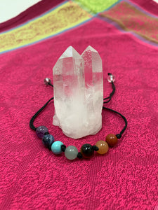 Adjustable Chakra power bracelet consists of 7 stones, one representing each of the 7 major chakras. It is artfully strung together with a strong, thin black cord and a tiny black knot between each chakra stone. Two additional clear quartz crystal stones embellish the adjustable part of the bracelet. 