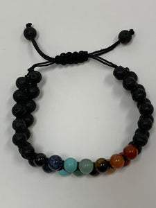 Close-up view. Adjustable lava power bracelet with double rows, one on top of the other, of both lava and chakra beads which are tightly strung together with a strong, thin black cord. The bracelet is adjustable. Lava is very grounding, calming and protective. Beads are 8mm. This is one powerful bracelet!