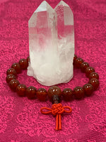 Load image into Gallery viewer, Second close-up view. Carnelian power bracelet accented with red Chinese tassel knot. Beads are 8 mm. Carnelian promotes courage, creativity, vitality and dispels emotional negativity.
