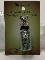 Load image into Gallery viewer, Close-up view. Small corked gemstone chip bottle necklace with moss agate gemstone chips inside, accented with a silver-colored turtle and fancy jewelry bail on the outside. Comes with a thin suede cord to wear as necklace.
