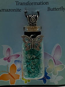 Close-up view of the gemstone chip (corked) bottle necklace. Inside are amazonite gemstone chips, accented on the outside by a silver-colored butterfly and fancy little jewelry bail (silver is not sterling). It comes with a thin suede cord to use as a necklace.