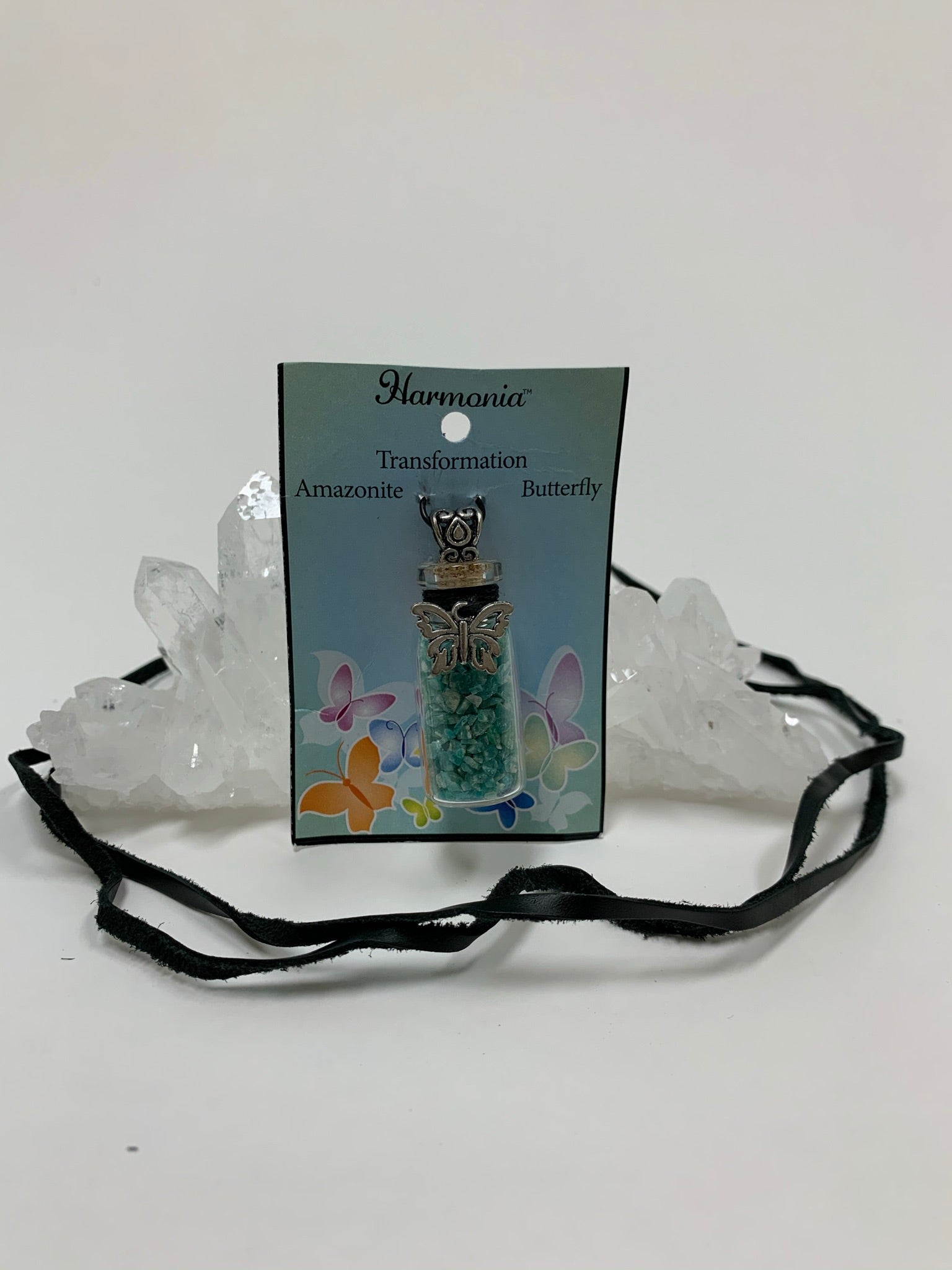 View displaying the suede cord of the gemstone chip (corked) bottle necklace. Inside are amazonite gemstone chips, accented on the outside by a silver-colored butterfly and fancy little jewelry bail (silver is not sterling). It comes with a thin suede cord to use as a necklace.