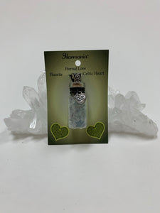 Gemstone chip (corked) bottle necklace with little fluorite chips inside and accented on the outside with a silver-colored Celtic heart and a fancy jewelry bail. It comes with a thin black suede cord so the bottle can be worn as a necklace.