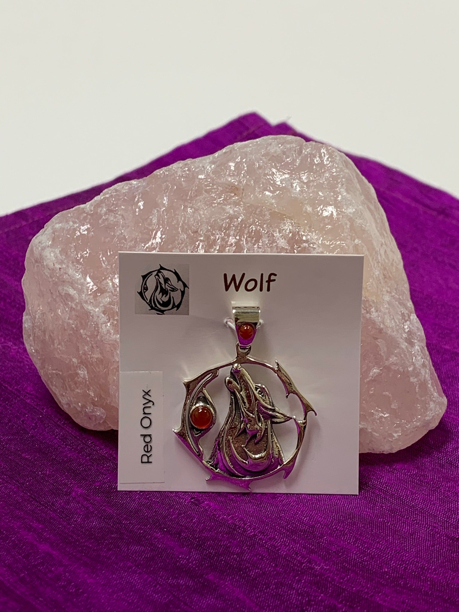 Sterling Silver wolf spirit animal pendant. Howling wolf (head and part of body) inside a fancy, stylized circle. Two red onyx gemstones (cabs), one on the actual pendant and one on the bail. Wear your spirit animal on your chest and carry it with you wherever you go! (Pendant only, no necklace chain).