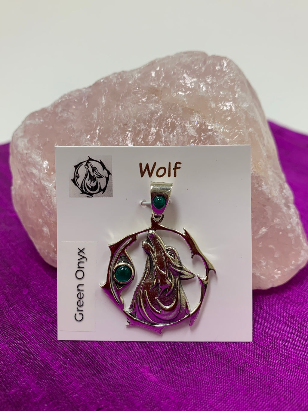 Sterling silver wolf spirit animal pendant. The sterling silver wolf is howling and consists of the head, neck and part of the body. It is inside of a stylized sterling circle and has two green onyx gemstones (cabs), one on the actual pendant, beside the wolf, and one on the pendant's bail. Wear this wolf symbol on your chest and carry its energy wherever you go. This is a pendant only - there is not a necklace chain included.