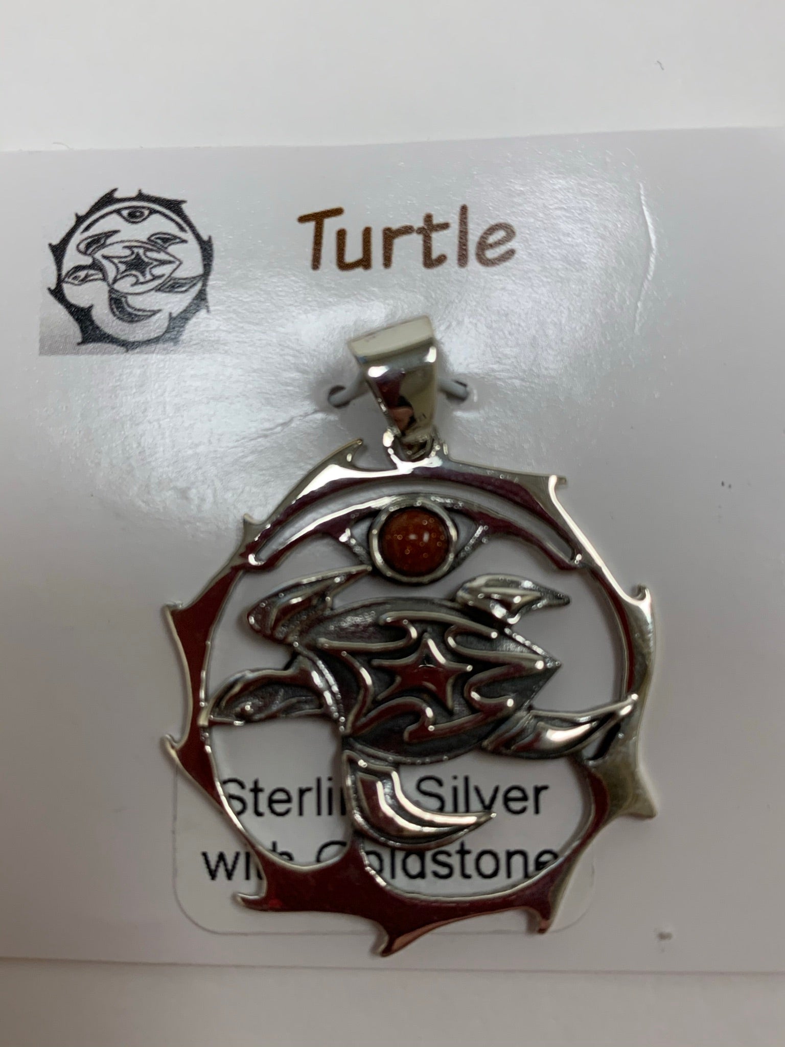 Close-up view of the sterling silver sea turtle spirit animal pendant with goldstone. Sea turtle is set within a stylized silver circle, with the goldstone above it. Where your spirit animal upon your chest so its energy is with you everywhere you go. Pendant only - necklace chain not included.
