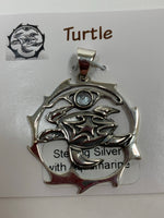 Load image into Gallery viewer, Close-up view. Sterling silver spirit animal, sea turtle, pendant accented with an aquamarine gemstone. Sea turtle is set in an open, sterling silver, circle with the aquamarine above it. Wear your spirit animal so you have it everywhere you go! Pendant only - necklace chain not included.
