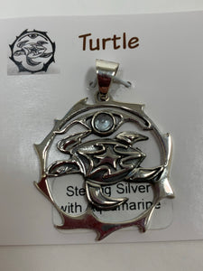 Close-up view. Sterling silver spirit animal, sea turtle, pendant accented with an aquamarine gemstone. Sea turtle is set in an open, sterling silver, circle with the aquamarine above it. Wear your spirit animal so you have it everywhere you go! Pendant only - necklace chain not included.