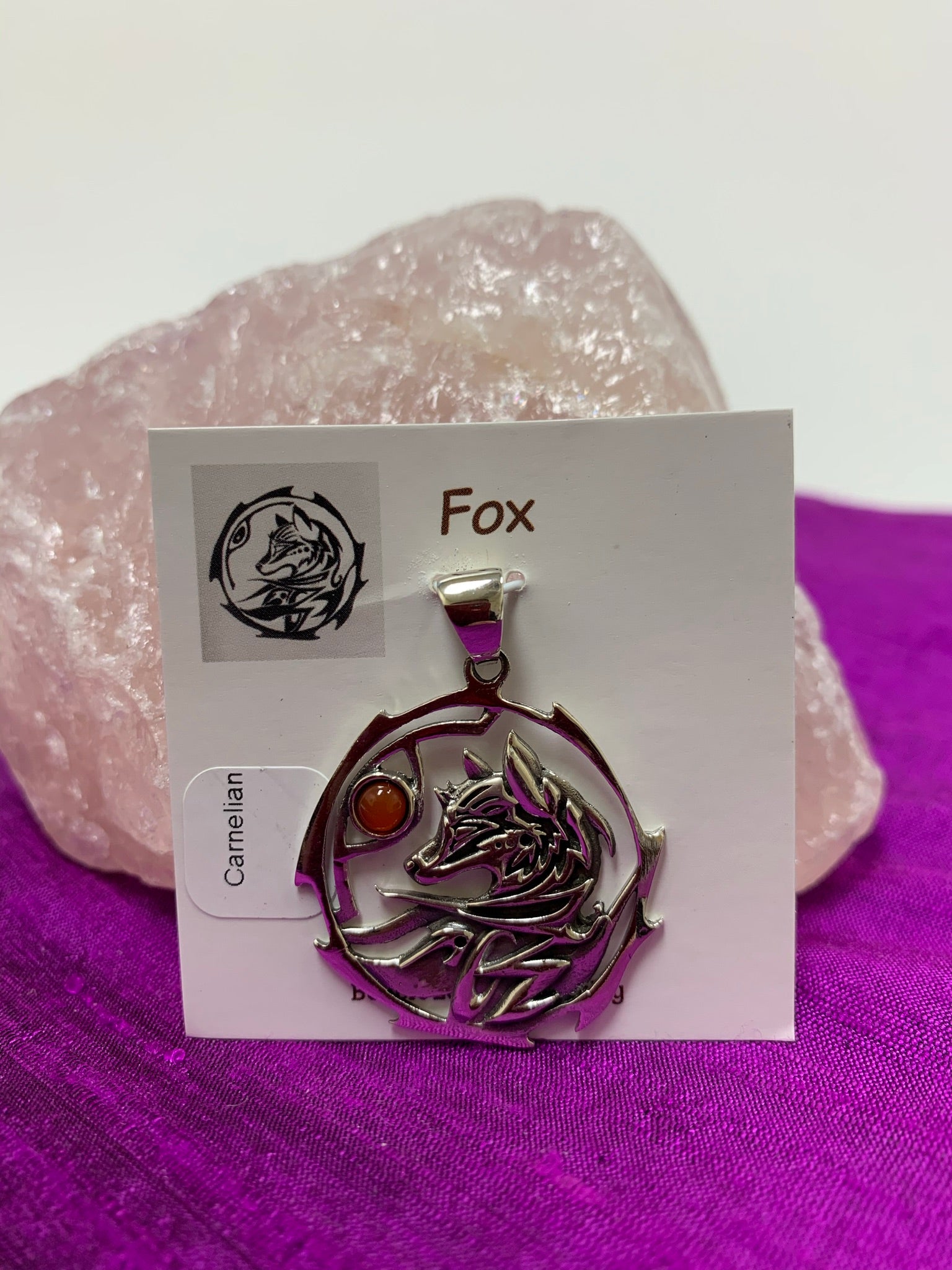 Sterling silver fox animal spirit pendant accented with a carnelian gemstone. The sterling silver fox is set inside an open, stylized sterling silver circle with the carnelian alongside of it. Wear your spirit animal and take its energy everywhere you go! Pendant only - necklace chain not included. 