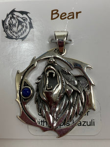 Close-up view. Sterling silver bear animal spirit pendant, accented with lapis gemstone. Bear (mostly head neck area) is set inside an open, stylized circle (bear and circle are sterling). Wear your animal spirit's energy so you have it with you everywhere you go! Pendant only - necklace chain not included.