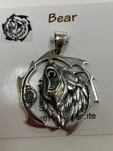 Close-up view. Sterling silver bear animal pendant, accented with a labradorite gemstone. The bear (mostly head neck area) is set within an open, stylized circle with the gemstone on the side (bear and circle both sterling). Wear your animal spirit's energy so you can take it anywhere you go! Pendant only - necklace chain not included.