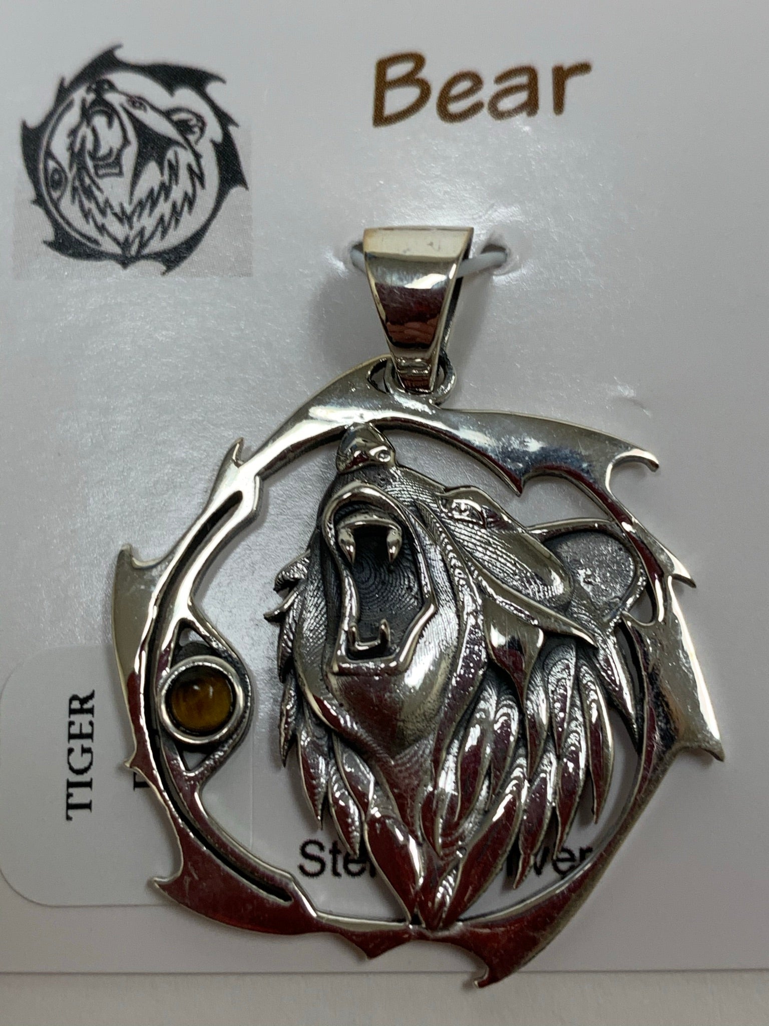 Sterling silver bear animal pendant, accented with a tiger eye gemstone. Bear is set within an open, stylized circle with the gemstone along the side (bear and circle are sterling). Wear your spirit animal's energy so you have it everywhere you go! Pendant only - necklace chain not included.