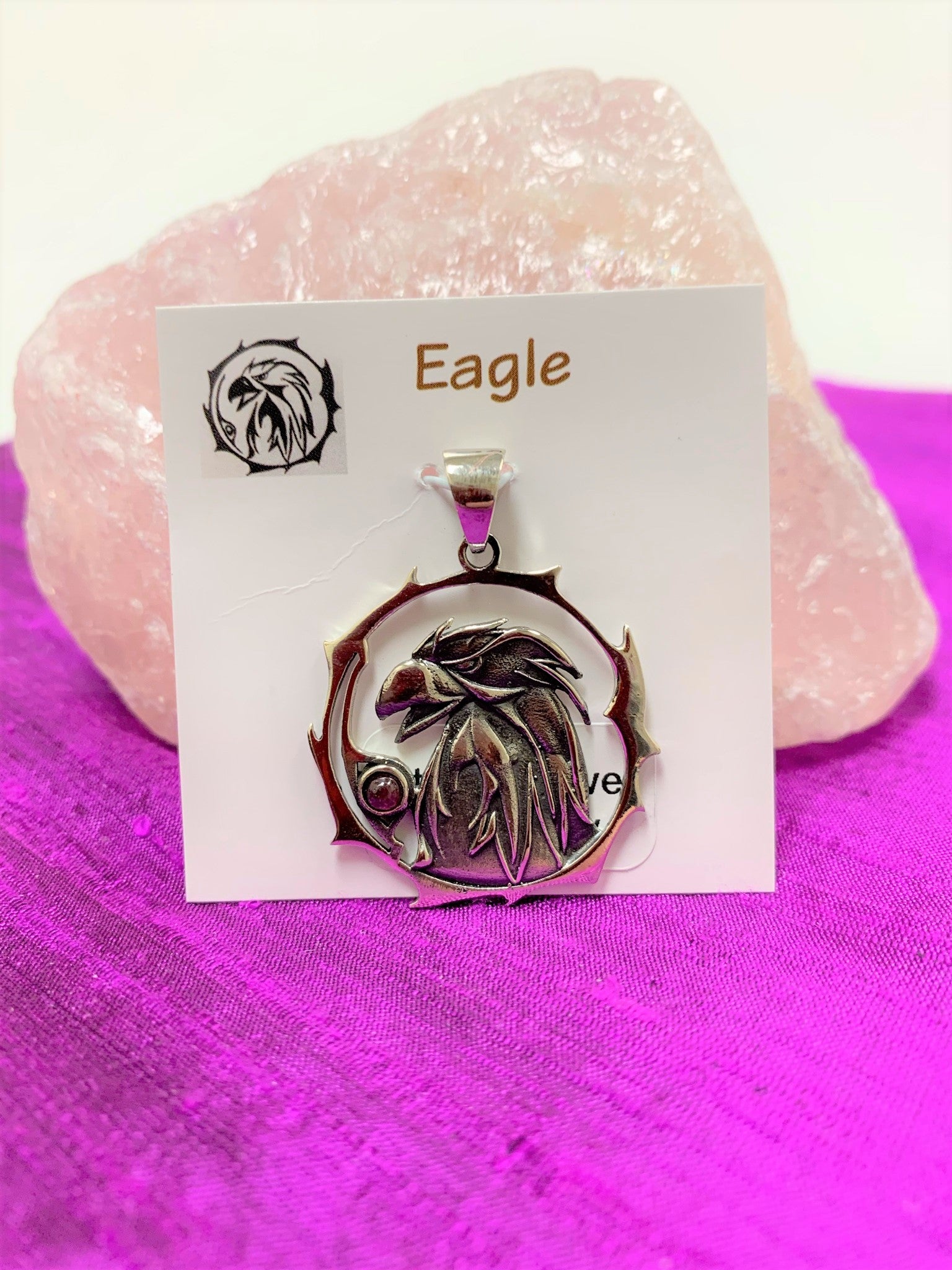 Sterling silver eagle animal spirit pendant, accented with a ruby gemstone. Eagle (head and neck) is set within an open, stylized circle with the ruby set along the side (eagle and circle are sterling). Wear your spirit animal's energy so you have it everywhere you go! Pendant only - necklace chain not included.