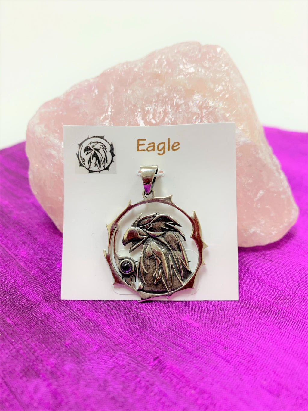 Sterling silver eagle animal spirit pendant, accented with an amethyst gemstone. Eagle (head and neck) is set within an open, stylized circle with the amethyst along the side (eagle and circle are sterling). Wear your spirit animal's energy so you can have it everywhere you go. Pendant only - necklace chain not included. 