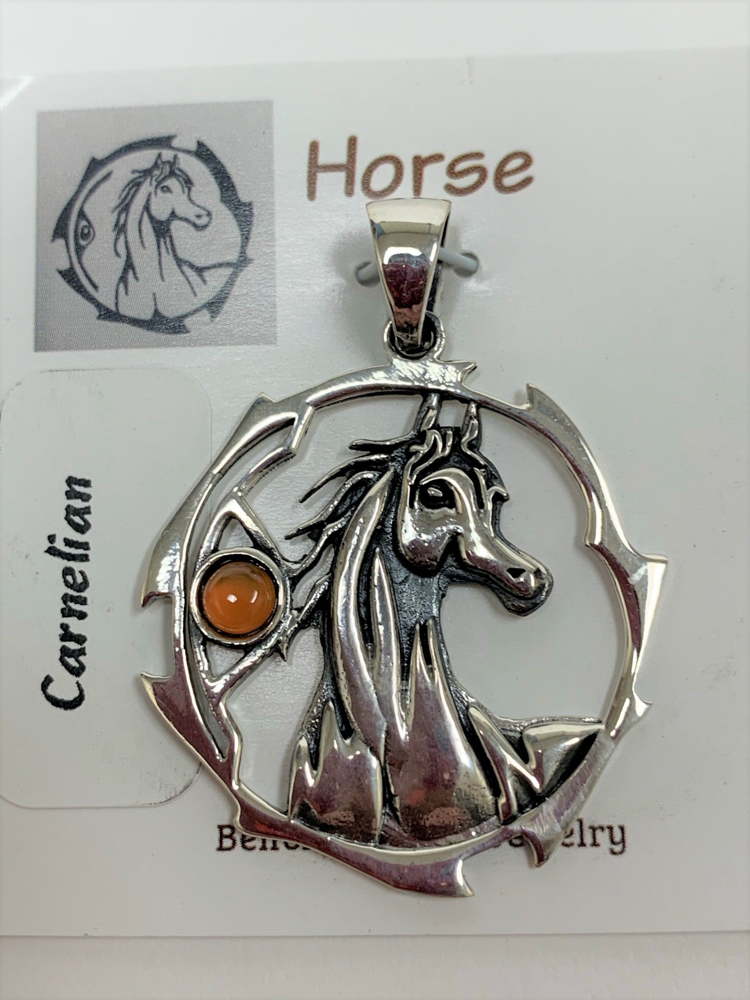 Close-up view. Sterling silver horse spirit animal pendant, accented with a carnelian gemstone. Horse is set within an open, stylized circle with the gemstone on the side (horse and circle are sterling). Wear your spirit animal so you have its energy everywhere you go! Pendant only - necklace chain not included.