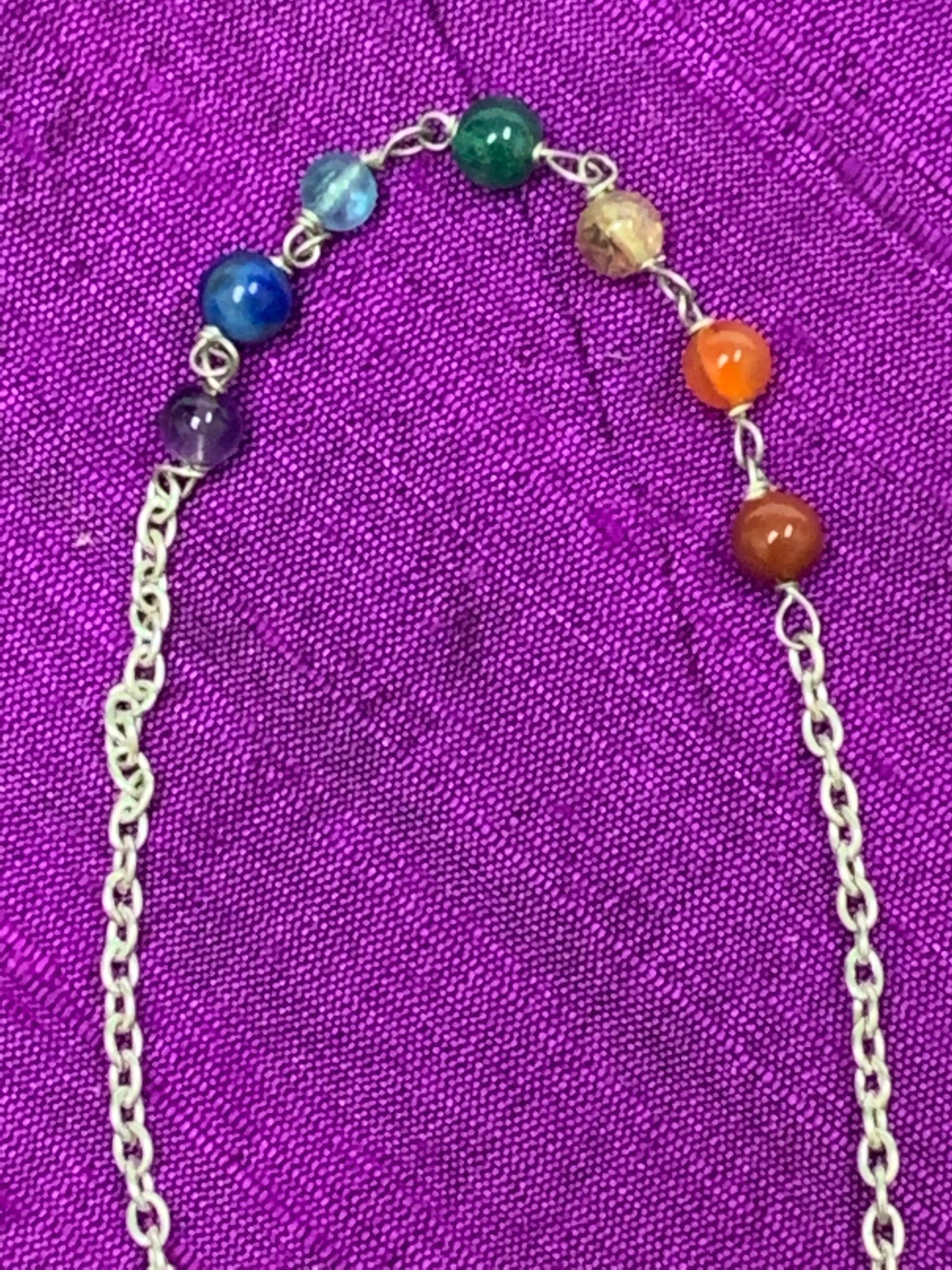 Close-up view of the 7 chakra beads on the pendulum's chain.