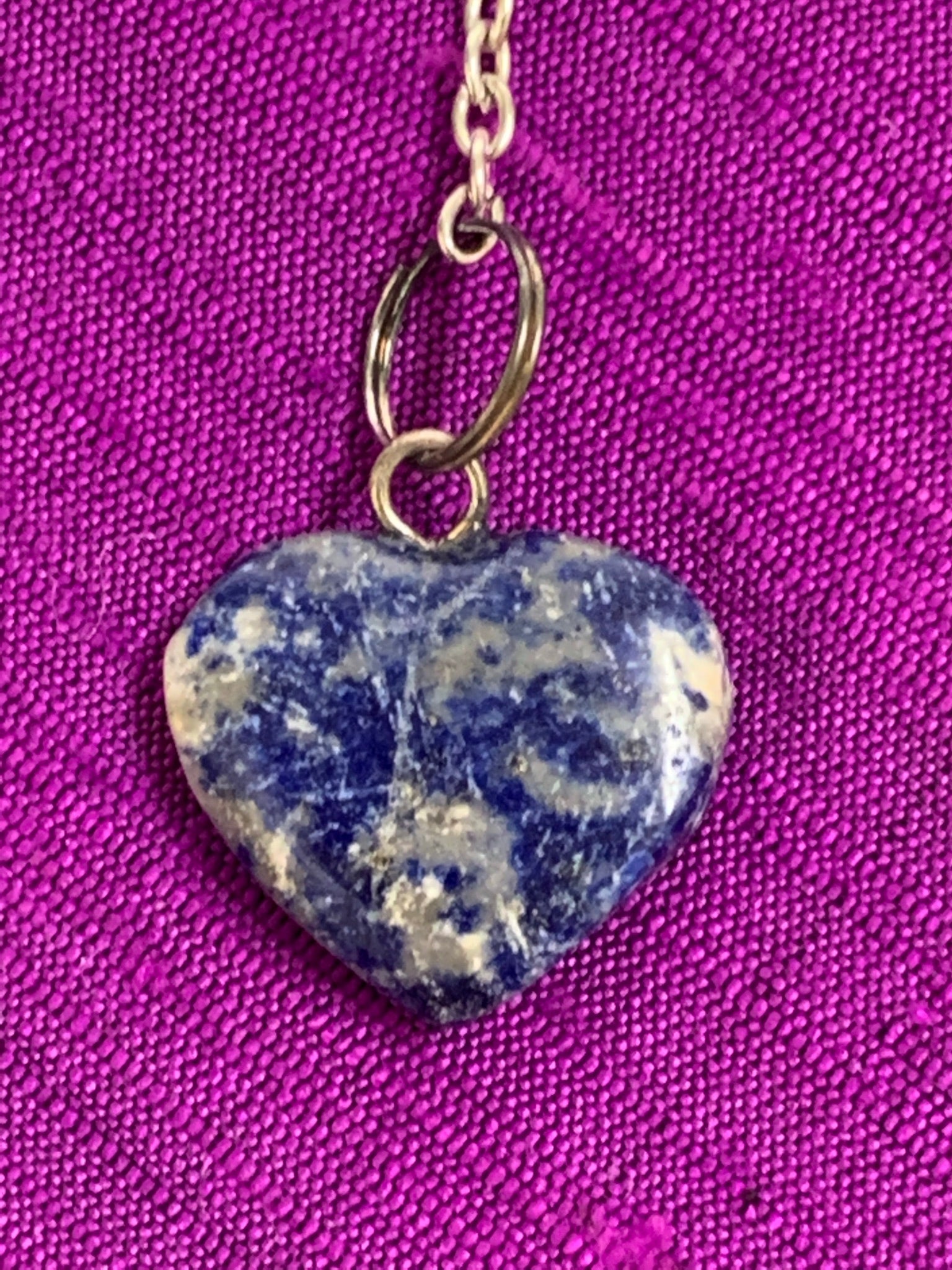 Close up view of the lapis heart at the end of the pendulum's chain.