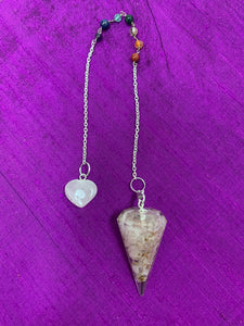 Orgonite pendulum with Rose Quartz crystals, accented on its chain by 7 chakra gemstone beads, one for each of the 7 major chakras and a rose quartz heart at the end of its chain. 