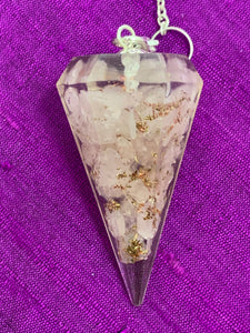 Close-up view. Orgonite pendulum with Rose Quartz crystals, accented on its chain by 7 chakra gemstone beads, one for each of the 7 major chakras and a rose quartz heart at the end of its chain.