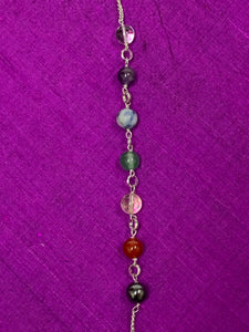 Close-up view of the 7 chakra beads displayed on the silver-colored (not sterling) pendulum chain.