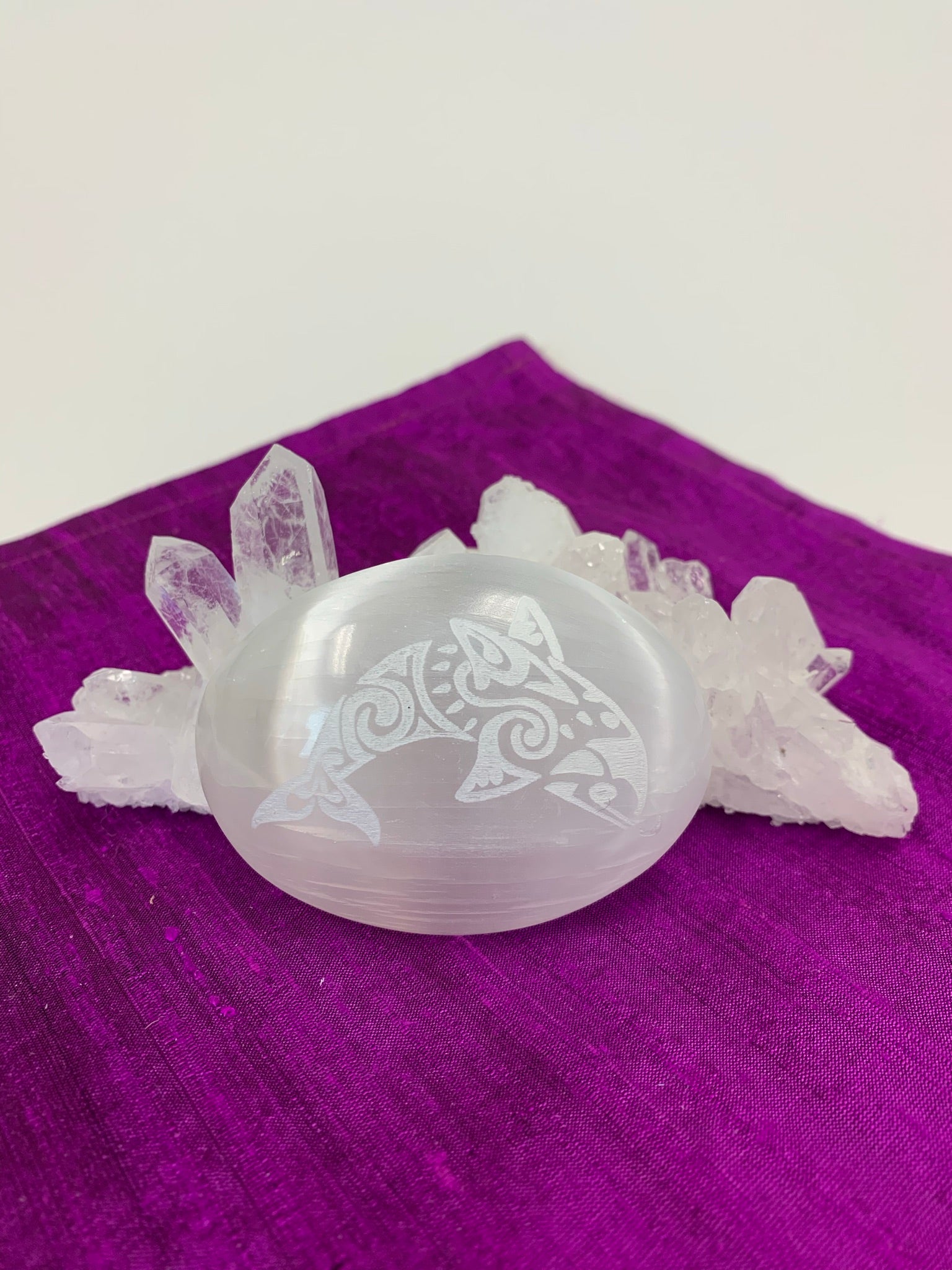 Etched dolphin on smooth, polished, white selenite palm stone. Selenite ranges from translucent to milky white. This selenite is ethically sourced and workers receive living wages.  Dolphin represents breath and playfulness and joy.