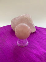 Load image into Gallery viewer, High quality Rose Quartz sphere is perfect for your altar, meditation space or to hold while meditating, or anywhere you want to radiate the energy of love ♥.  Rose quartz is the &quot;stone of unconditional love &amp; infinite peace.&quot; It opens the heart and soothes emotional distress. Size is approximately 2&quot;/40mm. Plastic stand as seen in photo, is included with your purchase.
