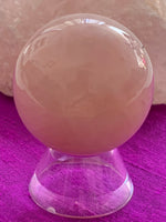 Load image into Gallery viewer, Close-up view with stand. High quality Rose Quartz sphere is perfect for your altar, meditation space or to hold while meditating, or anywhere you want to radiate the energy of love ♥. Rose quartz is the &quot;stone of unconditional love &amp; infinite peace.&quot; It opens the heart and soothes emotional distress. Size is approximately 2&quot;/40mm. Plastic stand as seen in photo, is included with your purchase.

