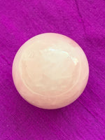 Load image into Gallery viewer, Close-up view without stand. High quality Rose Quartz sphere is perfect for your altar, meditation space or to hold while meditating, or anywhere you want to radiate the energy of love ♥. Rose quartz is the &quot;stone of unconditional love &amp; infinite peace.&quot; It opens the heart and soothes emotional distress. Size is approximately 2&quot;/40mm. Plastic stand as seen in photo, is included with your purchase.
