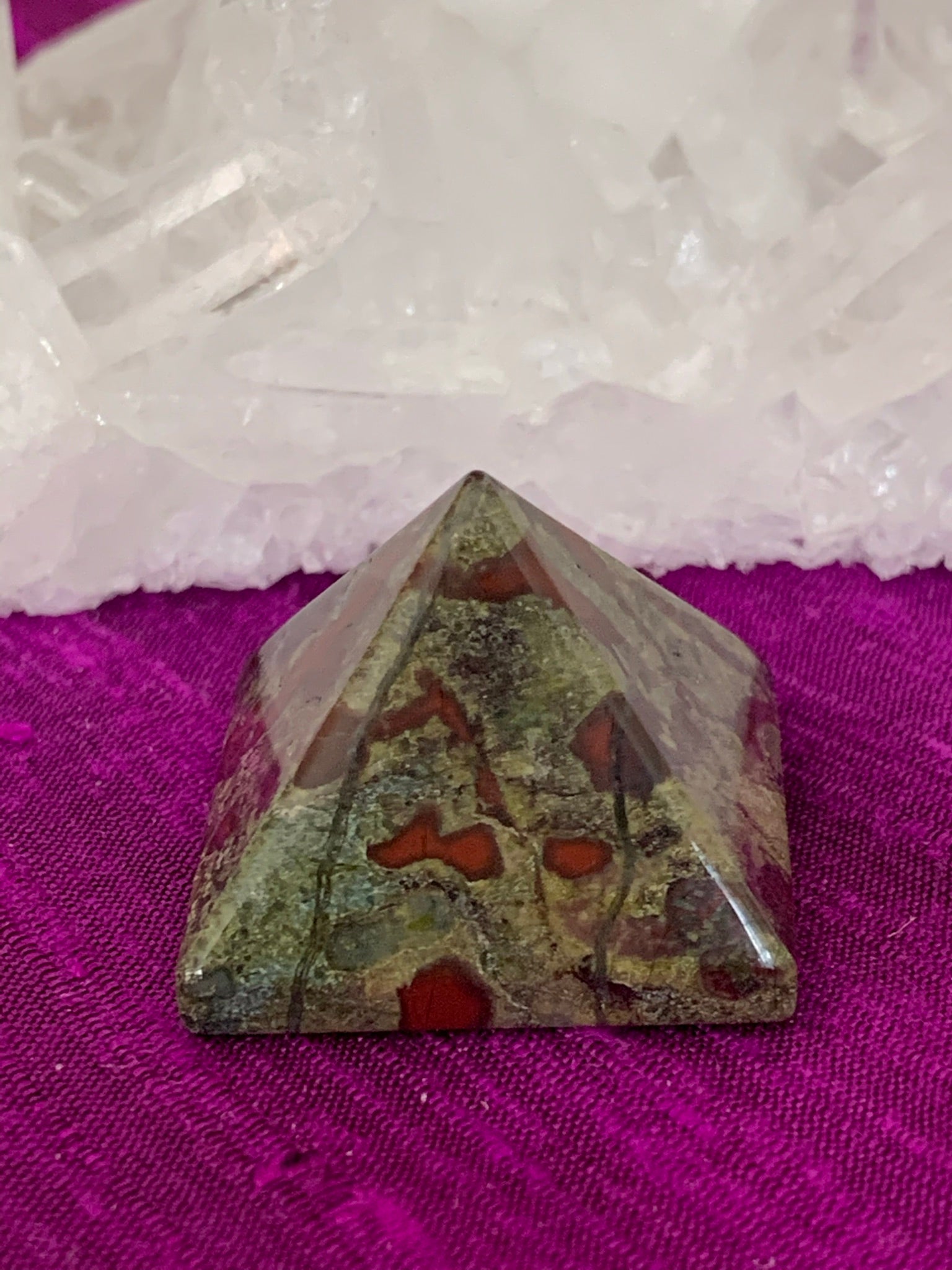 Close-up view . Powerful dragon blood (aka dragon stone) pyramid is perfect for your altar, meditation space or anywhere you want to radiate the energy of courage. Dragon stone jasper (a variety of quartz) is a stone of strength, courage and personal power. It enhances creativity and also attracts both money and love (themagicisinyou.com). It is also said to increase fertility. Size is approximately1"x1".