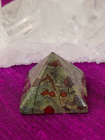 Load image into Gallery viewer, Close-up view . Powerful dragon blood (aka dragon stone) pyramid is perfect for your altar, meditation space or anywhere you want to radiate the energy of courage. Dragon stone jasper (a variety of quartz) is a stone of strength, courage and personal power. It enhances creativity and also attracts both money and love (themagicisinyou.com). It is also said to increase fertility. Size is approximately1&quot;x1&quot;.
