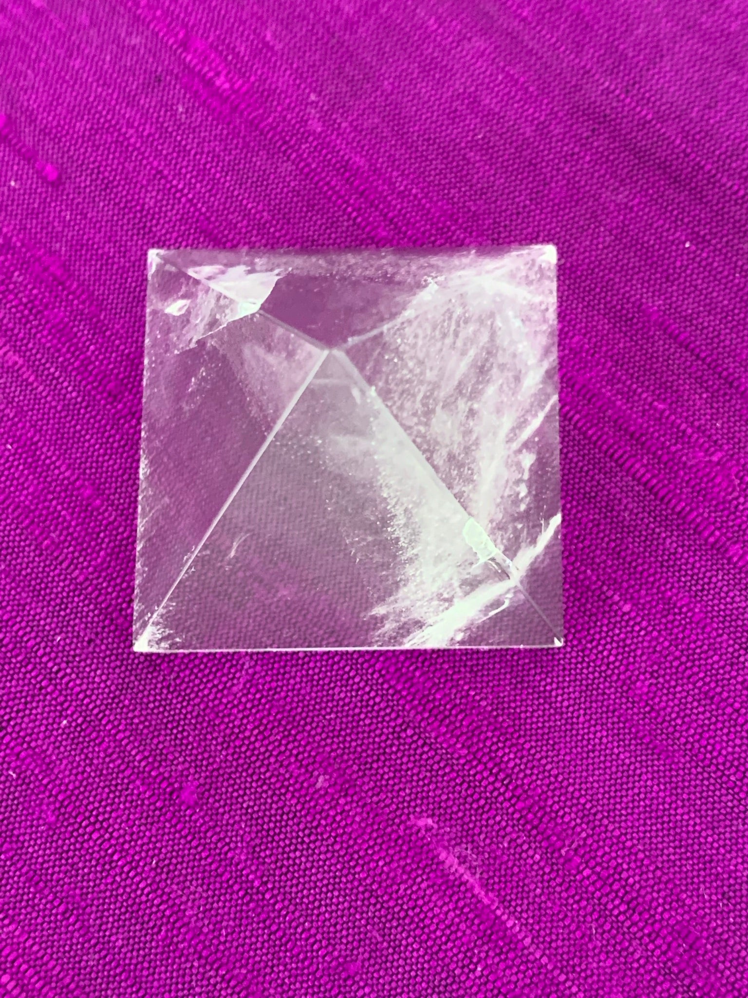 Close-up view from above. Powerful clear quartz pyramid is perfect for your altar, meditation space or anywhere in your home or office. This pyramid is cloudy or milky in appearance - more translucent than the other clear quartz pyramids. So, the clear vs the cloudy - it's all in the eye of the beholder ;). Quartz is the "most powerful healing and energy amplifier on the planet" (Judy Hall).  Pyramids are used to amplify and transform energy. Approximately 1"x1".