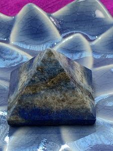 Close-up view. Powerful lapis pyramid is perfect for your altar, meditation space or anywhere in your home or office. Lapis enhances intuition and psychic abilities, brings peace and serenity, reveals inner truths, aids in self-expression, activates the third eye and and brings balance to the throat chakra. Pyramids are used to amplify and transform energy. Today "their likeness is used to charge crystals, herbs, pendulums, water, essential oils and other items. Approximately 1"x1".