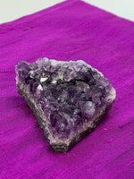 Load image into Gallery viewer, close-up view of amethyst geode piece - great quality and color. Size varies, but the average weight is 4.4oz. Each piece is unique in shape.
