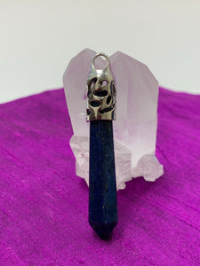 A second close-up view. Long Lapis crystal point is set in fancy silver (not sterling) bail. Lapis enhances intuition and psychic abilities, brings peace and serenity, reveals inner truths, aids in self-expression, activates the third eye and and brings balance to the throat chakra. Perfect for wearing to take advantage of its benefits all day long. Approximately 2½".