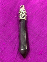 Load image into Gallery viewer, Close-up view. Long amethyst crystal point is set in a fancy silver bail (not sterling silver) for this powerful pendant. Amethyst, one of the most spiritual gemstones, heals, cleanses &amp; calms, allowing you to reach meditative &amp; higher consciousness levels more easily. It also helps to dispel negative emotional states. Perfect for wearing to take advantage of its benefits all day long. Approximately 2½&quot;.
