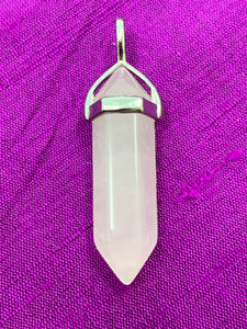 Close-up view. Double terminated rose quartz crystal is set in a silver-plated bail (not sterling silver) for this powerful pendant. Rose quartz is the "stone of unconditional love & infinite peace." It opens the heart and soothes emotional distress. Perfect for wearing to take advantage of its benefits all day long. Approximately 1½". 