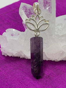 Close-up view. Amethyst crystal point dangles from an open sterling silver lotus. Amethyst, one of the most spiritual gemstones, heals, cleanses & calms, allowing you to reach meditative & higher consciousness levels more easily. It also helps to dispel negative emotional states. The lotus represents purity, strength and enlightenment. Approximately 2¼".