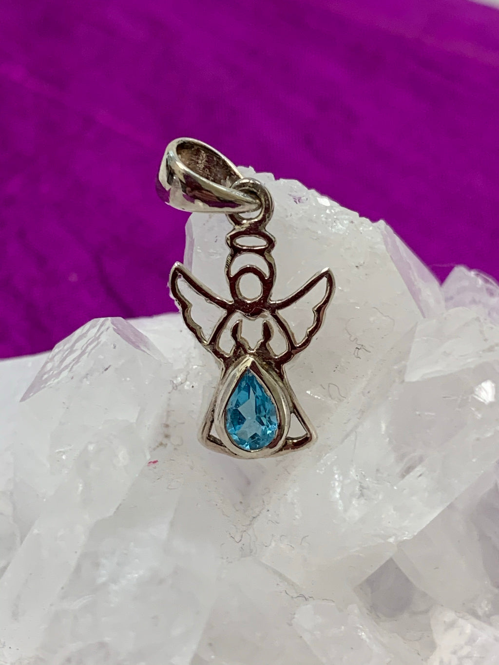 Dainty sterling silver angel pendant with stunning teardrop blue topaz. Blue topaz soothes & relaxes, is a stone of love and manifestation, verbal communication, emotional support and more. The angel reminds us that we are being watched over, always! Pendant is approximately 1" long. Cost is $18.00.