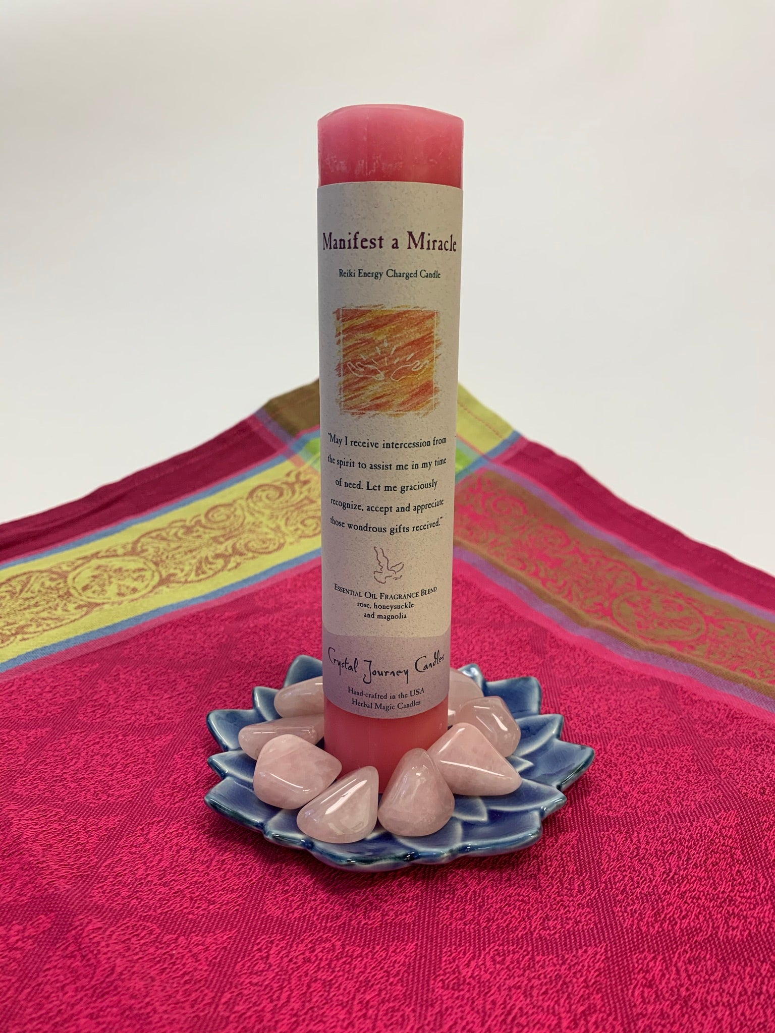 Reiki-charged pillar candle for "manifesting a miracle." It is handcrafted and scented using essential oils. An affirmation/prayer is printed on the label, as well as a listing of the essential oils used (rose, honeysuckle & magnolia). It is approximately 7"x1½." Perfect for meditation, prayer, visualization or quiet time. This pink candle and its label are both visually appealing.
