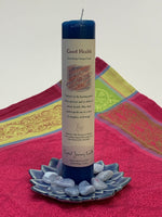 Load image into Gallery viewer, Reiki-charged pillar candle for &quot;Good Health.&quot; It is handcrafted and scented using essential oils. An affirmation/prayer is printed on the label, as well as a listing of the essential oils used (clove, nutmeg, lemon balm, poppy seed, cedar, honeysuckle, juniper). It is approximately 7&quot;x2½.&quot; Perfect for meditation, prayer, visualization or quiet time. This dark blue candle and its label are both visually appealing.
