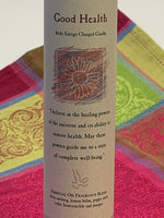 Load image into Gallery viewer, Close-up view of the Reiki-charged pillar candle for &quot;Good Health.&quot; It is handcrafted and scented using essential oils. An affirmation/prayer is printed on the label, as well as a listing of the essential oils used (clove, nutmeg, lemon balm, poppy seed, cedar, honeysuckle, juniper). It is approximately 7&quot;x2½.&quot; Perfect for meditation, prayer, visualization or quiet time. This dark blue candle and its label are both visually appealing.
