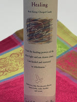 Load image into Gallery viewer, Close-up view of the Reiki-charged pillar candle for &quot;Healing.&quot; It is handcrafted and scented using essential oils. An affirmation/prayer is printed on the label, a well as a listing of the essential oils used (lemon balm, cedar, heather, ocean). It is approximately 7&quot;x2½&quot;. Perfect for meditation, prayer, visualization or quiet time. This deep purple candle and its label are both visually appealing.
