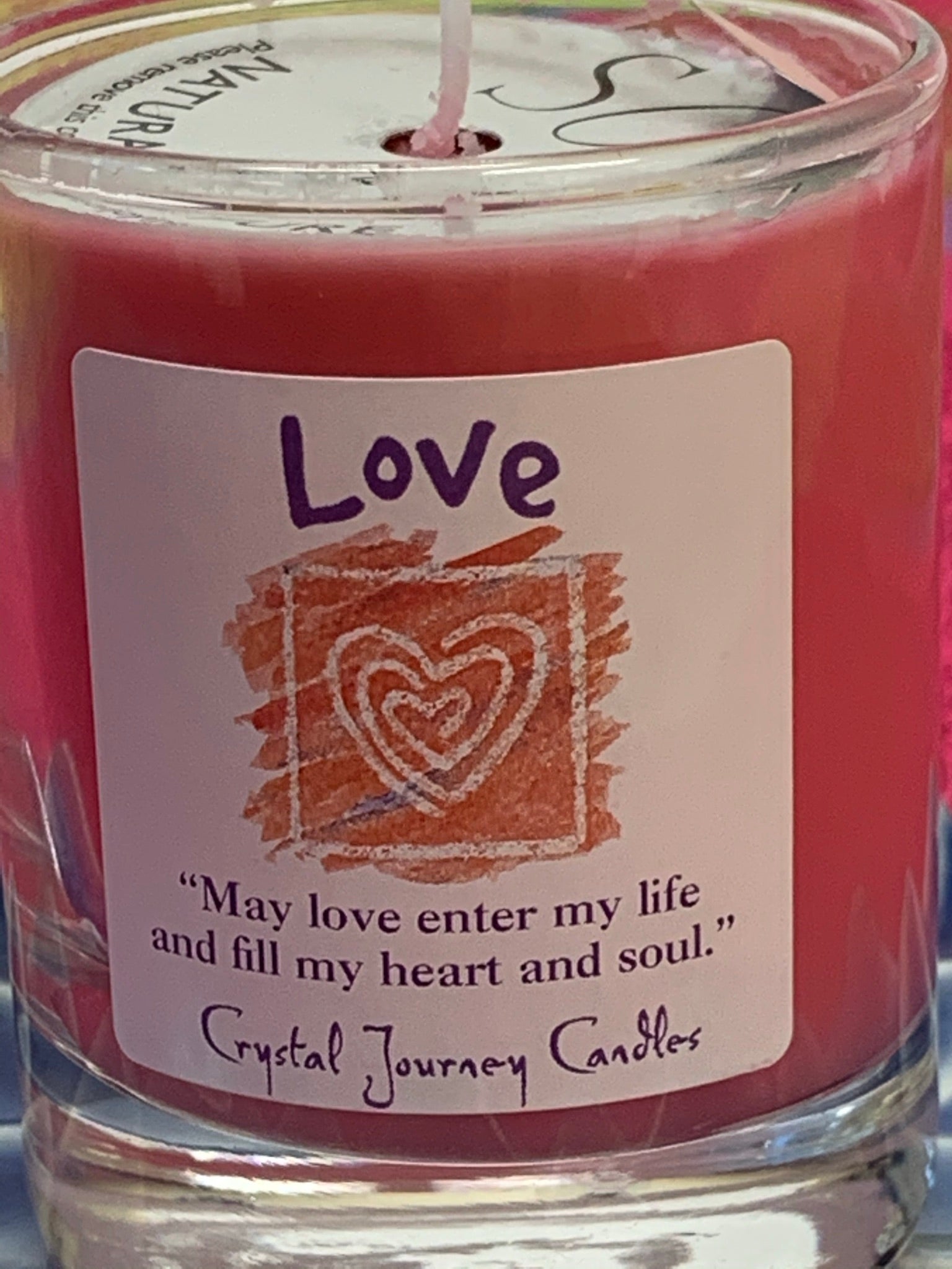 Close-up of the handcrafted pink votive candle in a glass holder. The wax is soy-based (no paraffin) and is also vegan. Wicks are made with paper and cotton only. It comes with an attractive label stating the intention/purpose of the candle, "Love," and an affirmation for your use: "May love enter my life and fill my heart and soul."