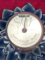 Load image into Gallery viewer, Close-up view of the candle from above, showing the silver-colored, cardboard, protective covering for the candle. 
