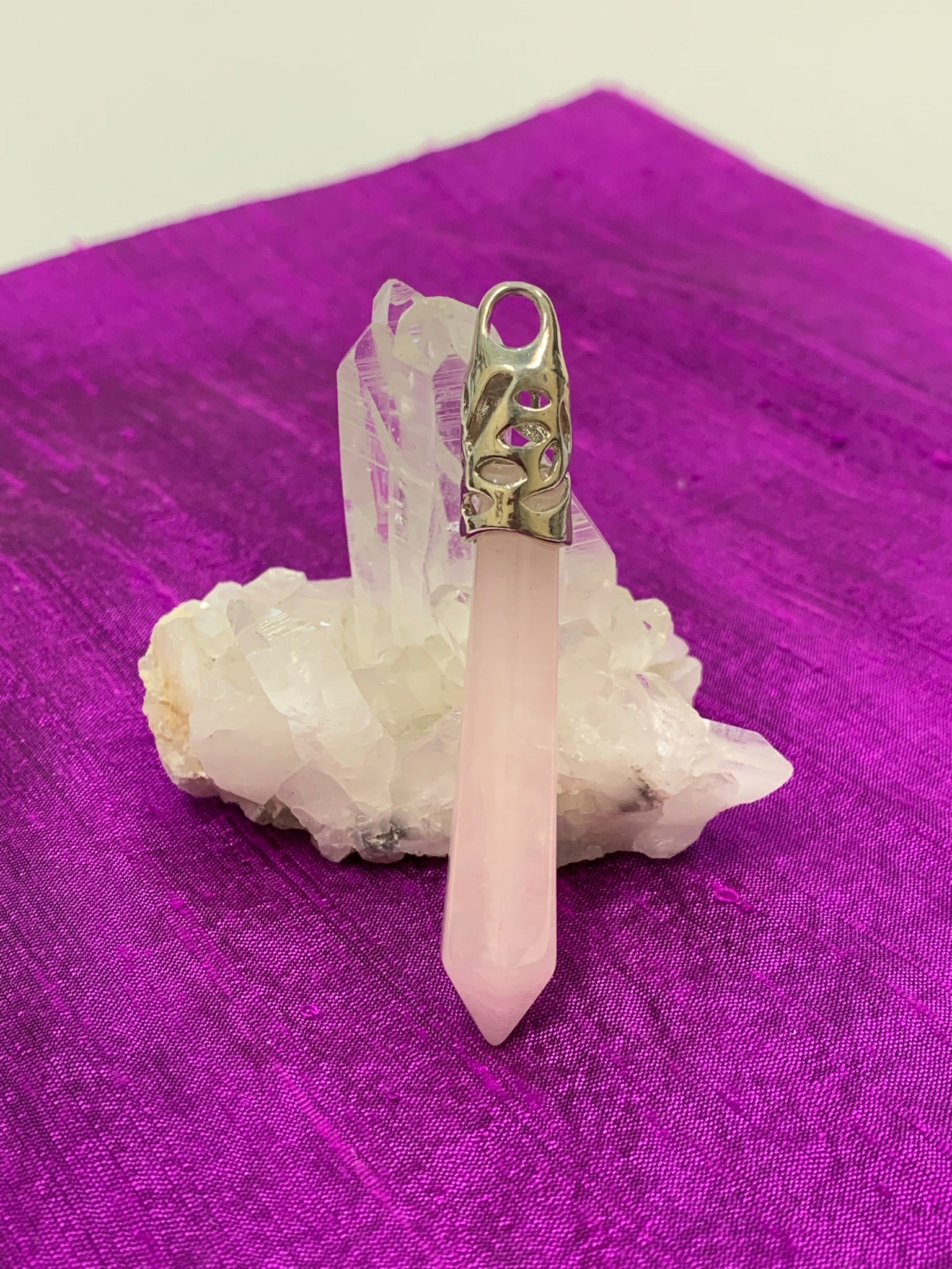 Long rose quartz crystal point is set in a fancy silver-plated bail (not sterling silver) for this powerful pendant. Rose quartz is the "stone of unconditional love & infinite peace." It opens the heart and soothes emotional distress. Perfect for wearing over your heart to take advantage of its benefits all day long. Approximately 2½-2¾".