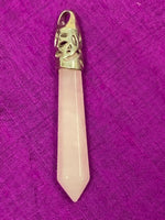 Load image into Gallery viewer, Close-up view of the long rose quartz crystal point set in a fancy silver-plated bail (not sterling silver) for this powerful pendant. Rose quartz is the &quot;stone of unconditional love &amp; infinite peace.&quot; It opens the heart and soothes emotional distress. Perfect for wearing over your heart to take advantage of its benefits all day long. Approximately 2½-2¾&quot;.
