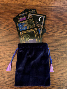 Small Purple (maybe very dark blue) velvet oracle deck/tarot bag lined with lavender satin. It is plain velvet without a design, but with drawstrings for closure. It is 5.75"x4.75" and suitable for small oracle or tarot decks (e.g. Shamanic Healing Oracle Cards or The Original Angel Cards). It can also be used to hold and protect small to medium size crystals, gemstones or other precious items. Cost is $4.99