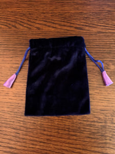 Another view of the bag. Small Purple (maybe very dark blue) velvet oracle deck/tarot bag lined with lavender satin. It is plain velvet without a design, but with drawstrings for closure. It is 5.75"x4.75" and suitable for small oracle or tarot decks (e.g. Shamanic Healing Oracle Cards or The Original Angel Cards). It can also be used to hold and protect small to medium size crystals, gemstones or other precious items. Cost is $4.99
