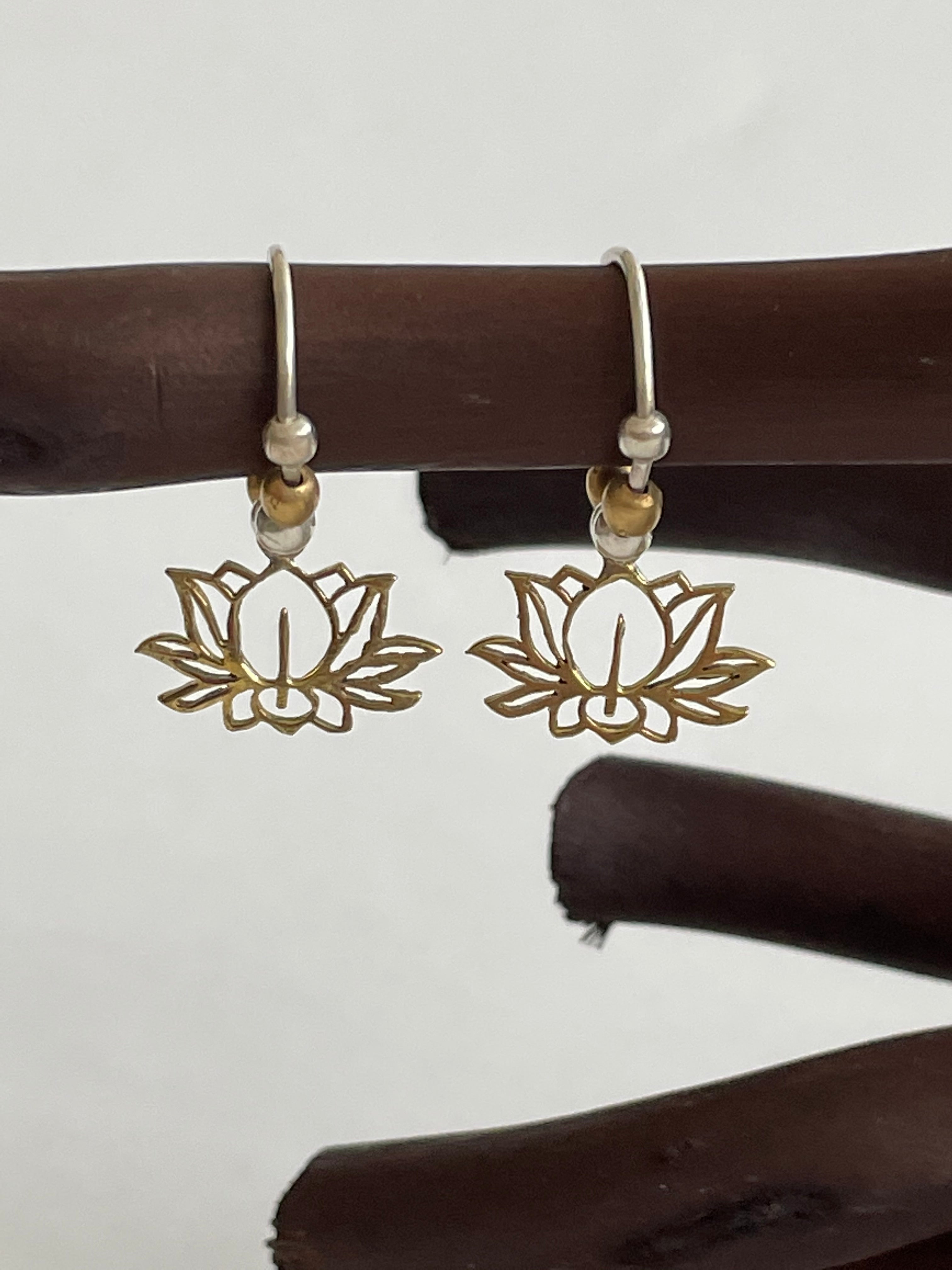 Lightweight, dainty hypoallergenic brass lotus earrings with brass and silver-colored beads. They are handmade and fair trade. Perfect gift for self or others. The lotus symbolizes purity, strength and enlightenment. It also reminds us that we all have to move through the mud to get to the light. Cost is $18.00.